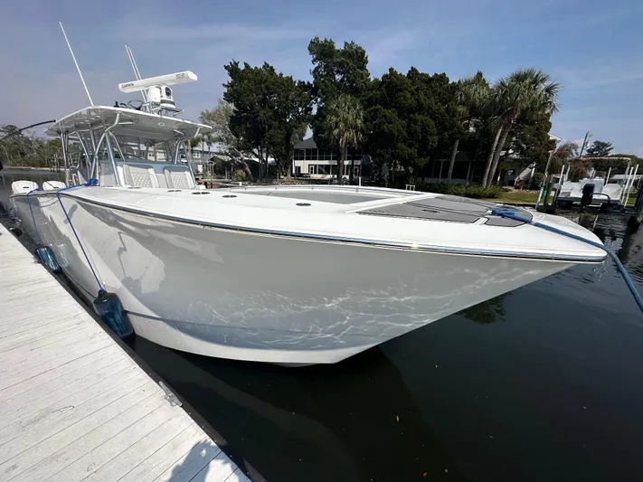 Knot Free Yacht Photos Pics 2021 SeaHunter 46 CTS boat docked at marina, sleek design, calm water reflection.