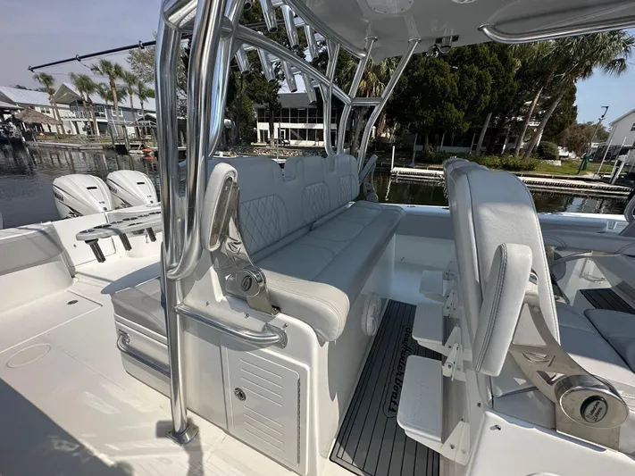 Knot Free Yacht Photos Pics 2021 SeaHunter 46 CTS boat interior with seating and rod holders, docked by palm trees.