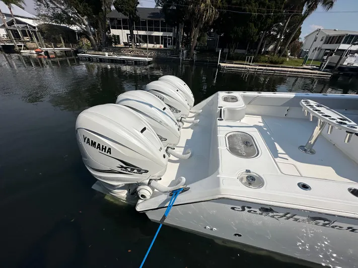 Knot Free Yacht Photos Pics 2021 SeaHunter 46 CTS with Yamaha outboard engines docked by the water.