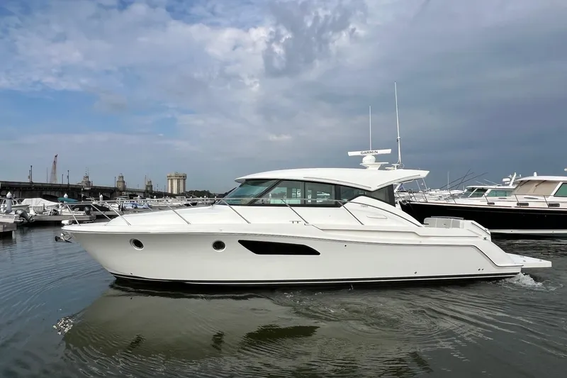 Salty Suite Yacht Photos Pics 2023 Tiara Yachts C44 Coupe in marina, sleek design, calm waters, overcast sky.