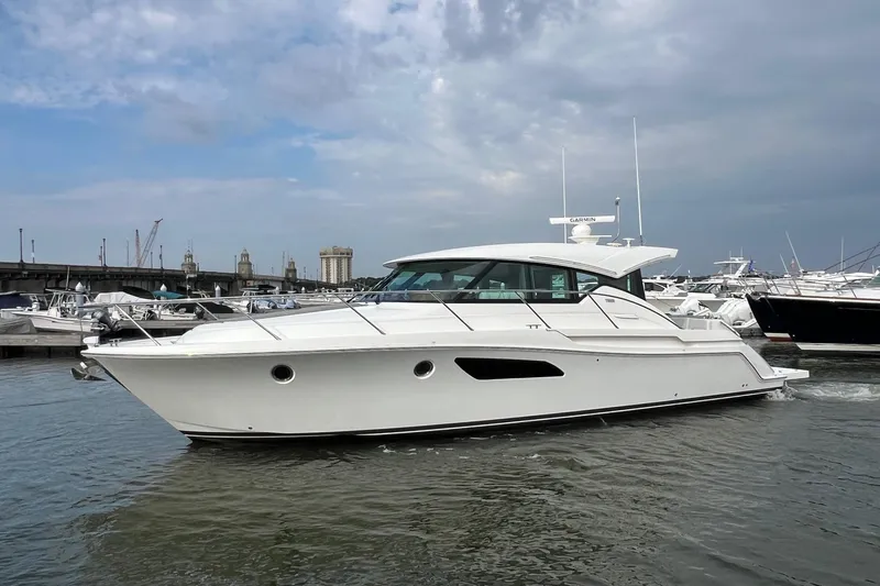 Salty Suite Yacht Photos Pics 2023 Tiara Yachts C44 Coupe in marina, sleek design, overcast sky.