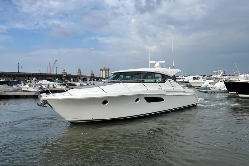 Salty Suite Yacht Photos Pics 2023 Tiara Yachts C44 Coupe in marina, sleek design, overcast sky.