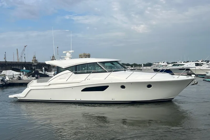 Salty Suite Yacht Photos Pics 2023 Tiara Yachts C44 Coupe in marina, sleek design, calm waters, overcast sky.