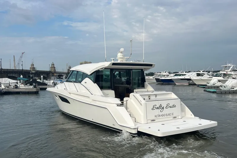 Salty Suite Yacht Photos Pics 2023 Tiara Yachts C44 Coupe in marina, rear view, overcast sky.