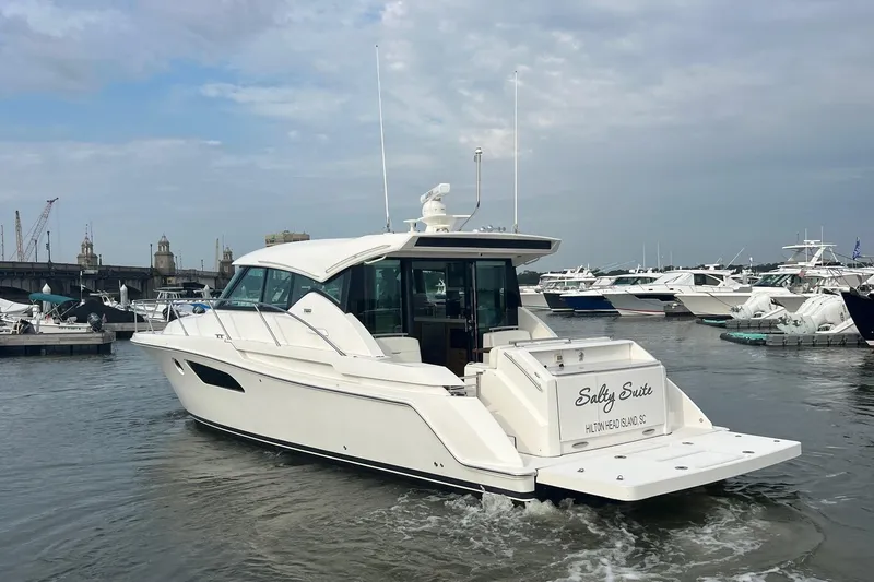 Salty Suite Yacht Photos Pics 2023 Tiara Yachts C44 Coupe in marina, rear view, overcast sky.