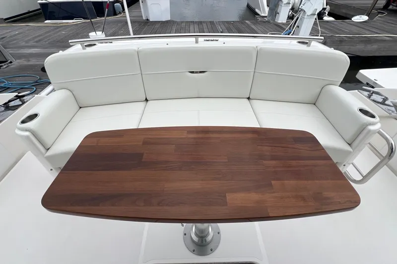 Salty Suite Yacht Photos Pics 2023 Tiara Yachts C44 Coupe interior with white seating and wooden table.