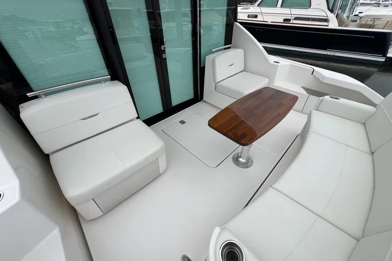 Salty Suite Yacht Photos Pics Luxurious 2023 Tiara Yachts C44 Coupe interior with elegant seating and wooden table.