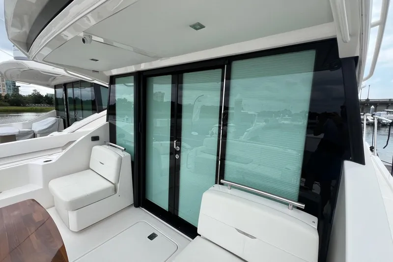 Salty Suite Yacht Photos Pics 2023 Tiara Yachts C44 Coupe, sleek exterior with glass doors and seating area.