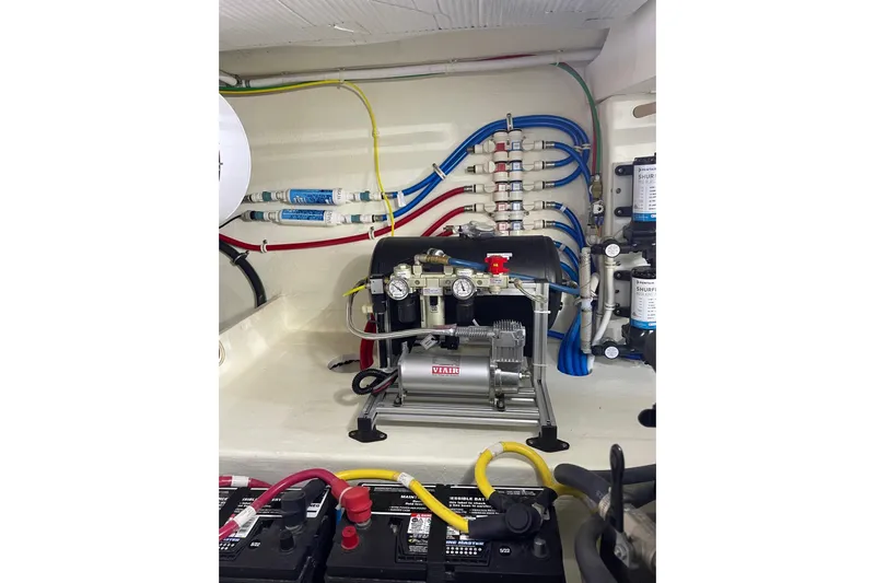 Salty Suite Yacht Photos Pics Engine room of 2023 Tiara Yachts C44 Coupe, showcasing wiring and equipment.