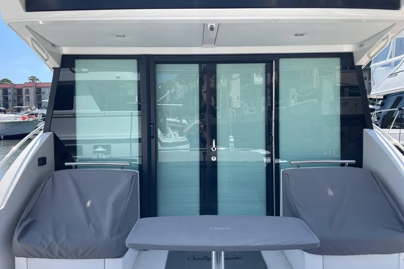 Salty Suite Yacht Photos Pics 2023 Tiara Yachts C44 Coupe, rear view with sliding glass doors and covered seating.