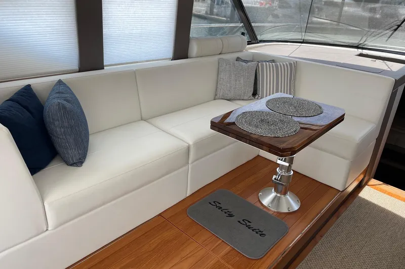 Salty Suite Yacht Photos Pics Luxurious interior of 2023 Tiara Yachts C44 Coupe with elegant seating and table.
