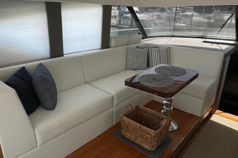 Salty Suite Yacht Photos Pics Luxurious interior of 2023 Tiara Yachts C44 Coupe with elegant seating and table.