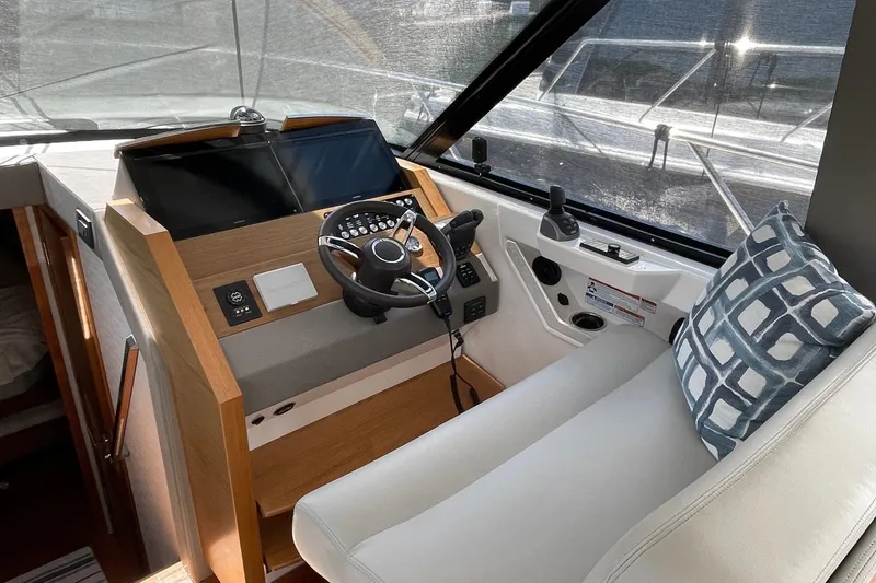 Salty Suite Yacht Photos Pics 2023 Tiara Yachts C44 Coupe helm with modern controls and cushioned seating.