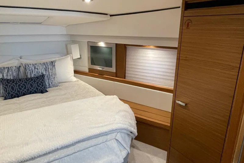 Salty Suite Yacht Photos Pics Luxurious bedroom interior of 2023 Tiara Yachts C44 Coupe with modern design and cozy bedding.