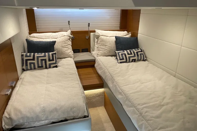 Salty Suite Yacht Photos Pics 2023 Tiara Yachts C44 Coupe interior with twin beds and decorative pillows.