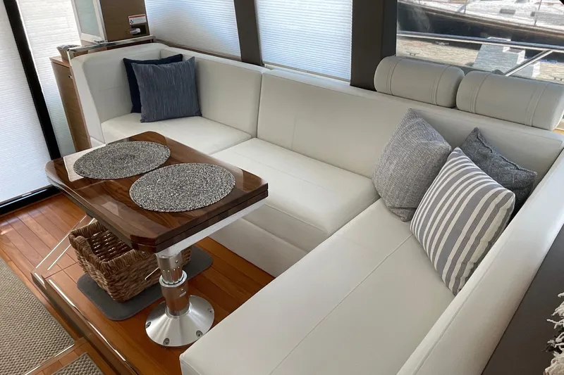 Salty Suite Yacht Photos Pics Luxurious interior of 2023 Tiara Yachts C44 Coupe with elegant seating and wooden table.
