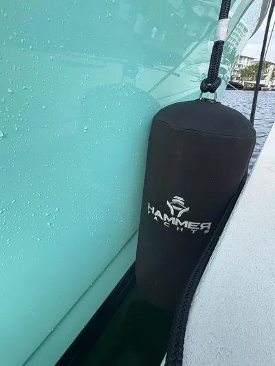 Hull 106 Yacht Photos Pics Hammer Yachts HammerCat 30, 2025 model, with branded fender against turquoise hull.