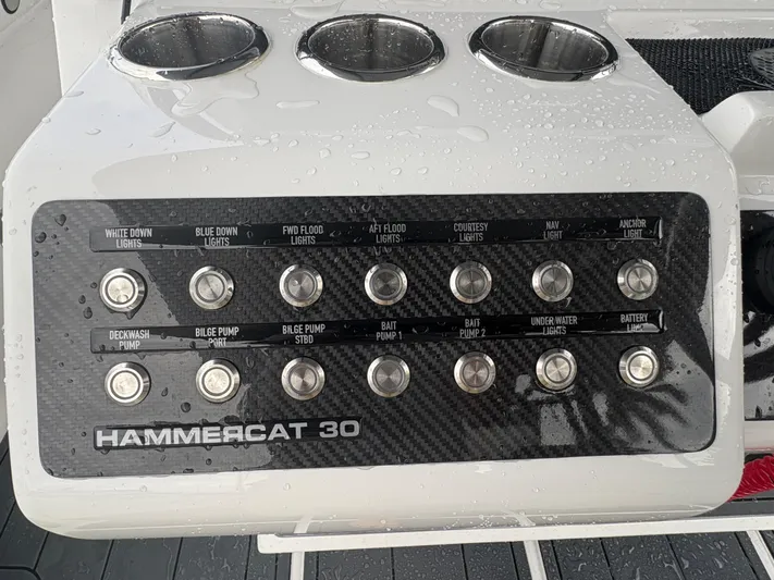 Hull 106 Yacht Photos Pics Control panel of 2025 Hammer Yachts HammerCat 30 with various switches and cup holders.