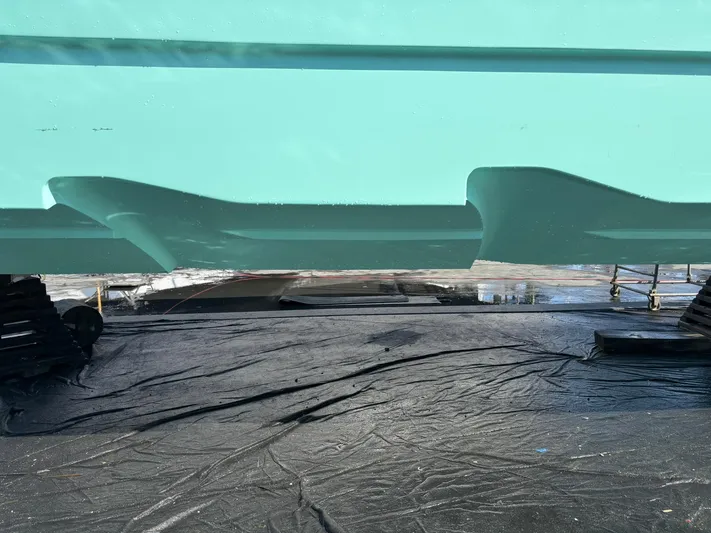 Hull 106 Yacht Photos Pics 2025 Hammer Yachts HammerCat 30 hull in dry dock, showcasing sleek design and turquoise color.