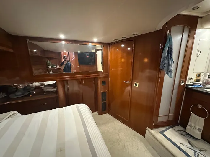  Yacht Photos Pics Luxurious interior of 2005 Carver 56 Voyager yacht bedroom with wood paneling and mirror.