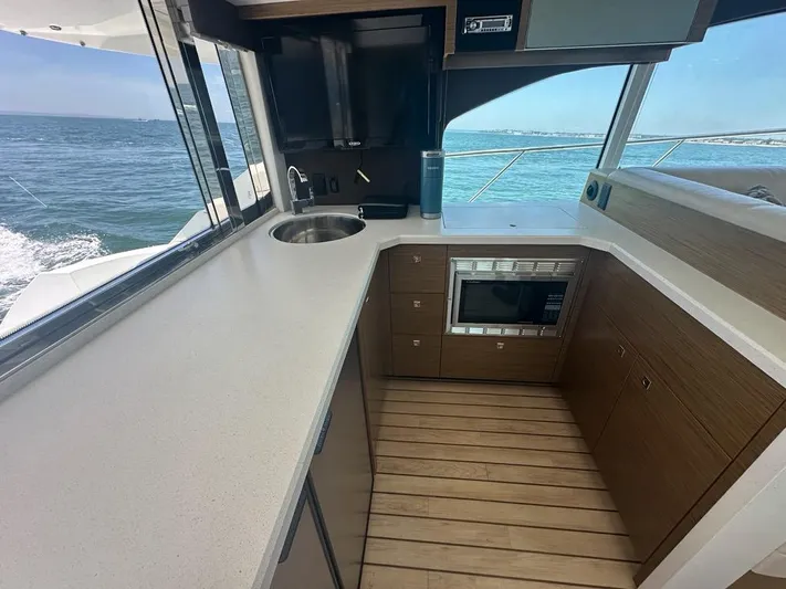 Jubilant Yacht Photos Pics 2015 Cruisers Yachts 45 Cantius kitchen with ocean view, featuring modern appliances and sleek design.