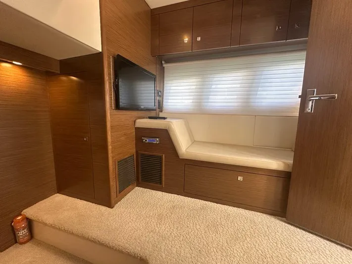 Jubilant Yacht Photos Pics Interior of 2015 Cruisers Yachts 45 Cantius with seating, TV, and wood paneling.