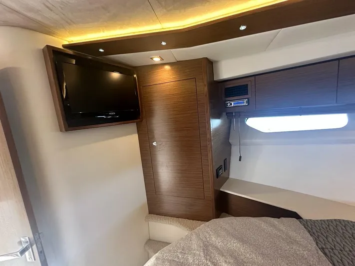 Jubilant Yacht Photos Pics 2015 Cruisers Yachts 45 Cantius cabin interior with TV, wood paneling, and ambient lighting.