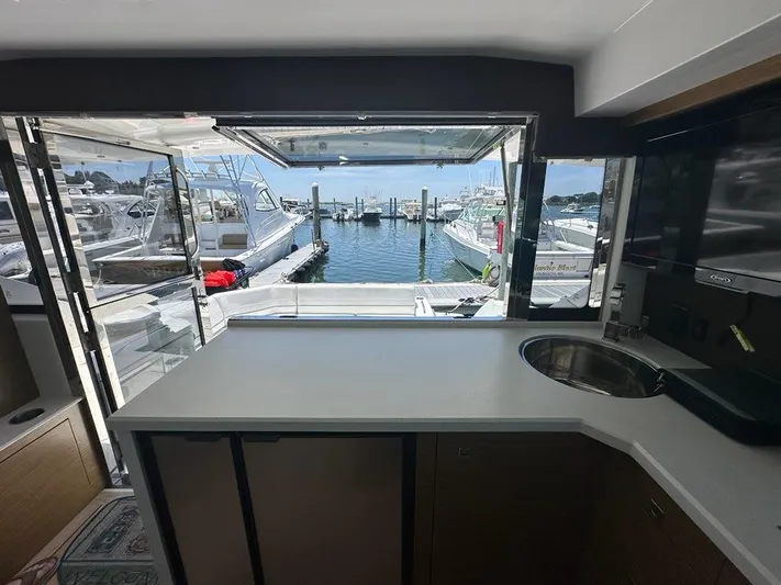 Jubilant Yacht Photos Pics Interior view of 2015 Cruisers Yachts 45 Cantius, overlooking marina through open window.