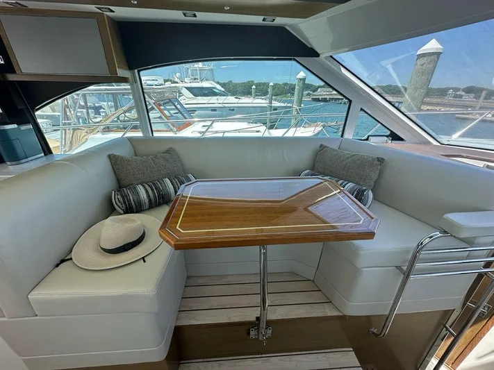 Jubilant Yacht Photos Pics Interior of 2015 Cruisers Yachts 45 Cantius with elegant seating and table.