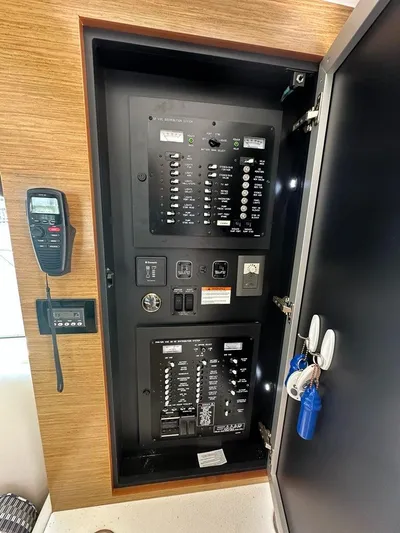 Jubilant Yacht Photos Pics Electrical panel inside a 2015 Cruisers Yachts 45 Cantius, featuring switches and a radio.