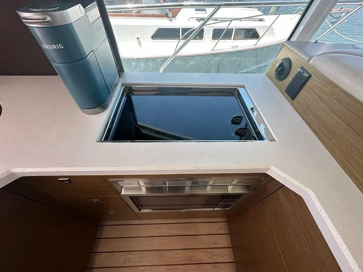 Jubilant Yacht Photos Pics Modern kitchen area on 2015 Cruisers Yachts 45 Cantius with stove and coffee maker.