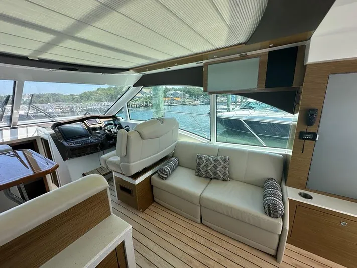 Jubilant Yacht Photos Pics Interior of 2015 Cruisers Yachts 45 Cantius with helm, seating, and waterfront view.