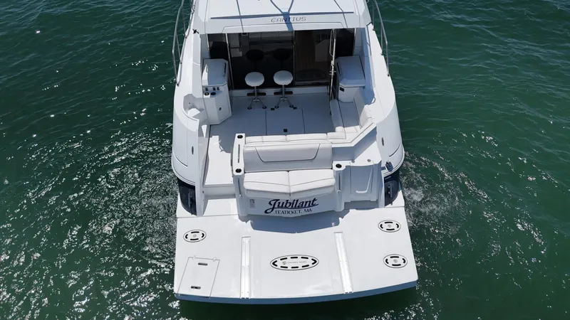 Jubilant Yacht Photos Pics 2015 Cruisers Yachts 45 Cantius on water, rear view with seating and deck.