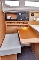  Yacht Photos Pics 2024 Jeanneau Sun Odyssey 410 interior with navigation station and seating area.