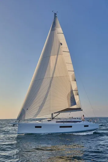  Yacht Photos Pics 2024 Jeanneau Sun Odyssey 410 sailing on open water under clear skies.