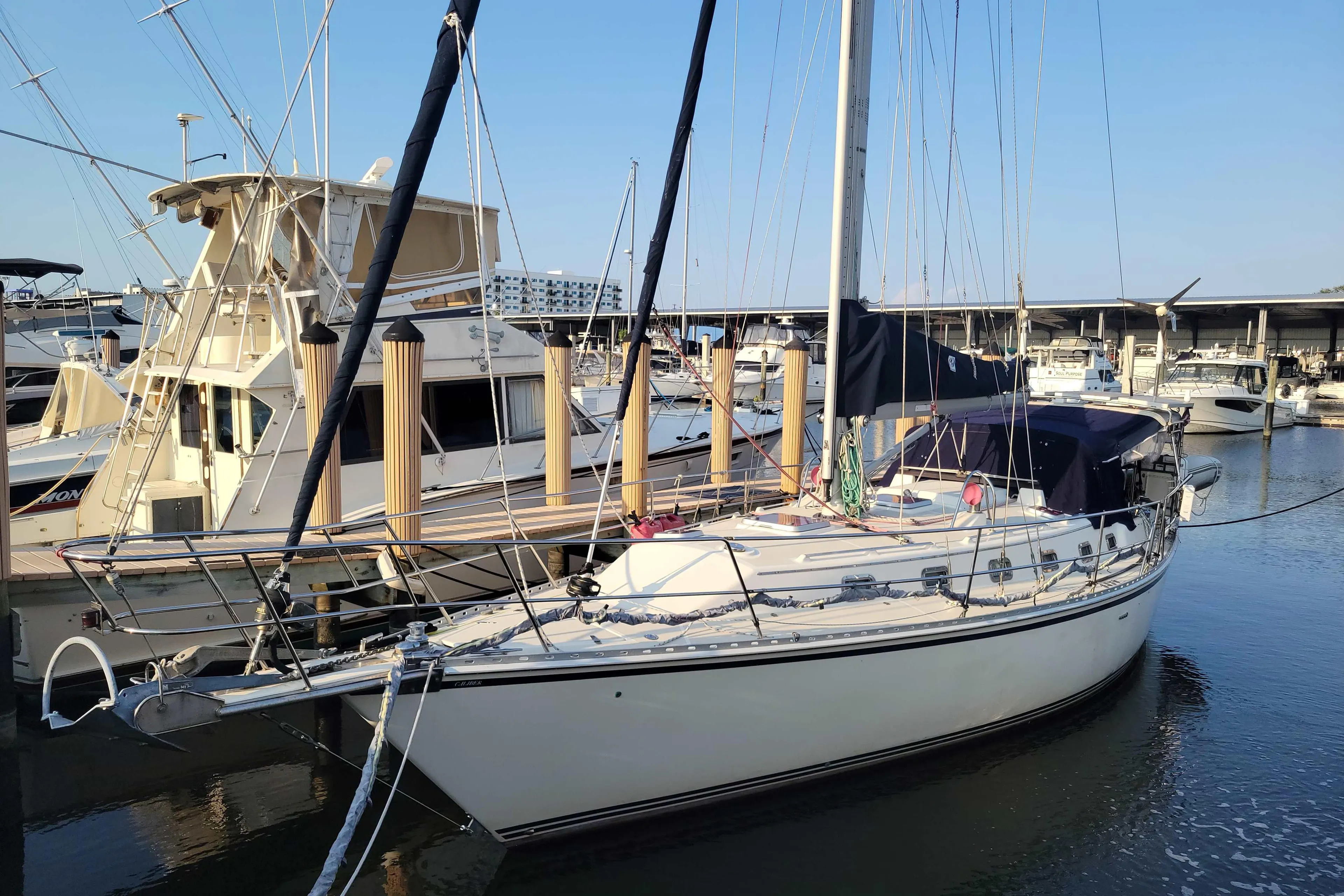 2005 Caliber 40 LRC SE sailboat docked in a marina, surrounded by other boats.