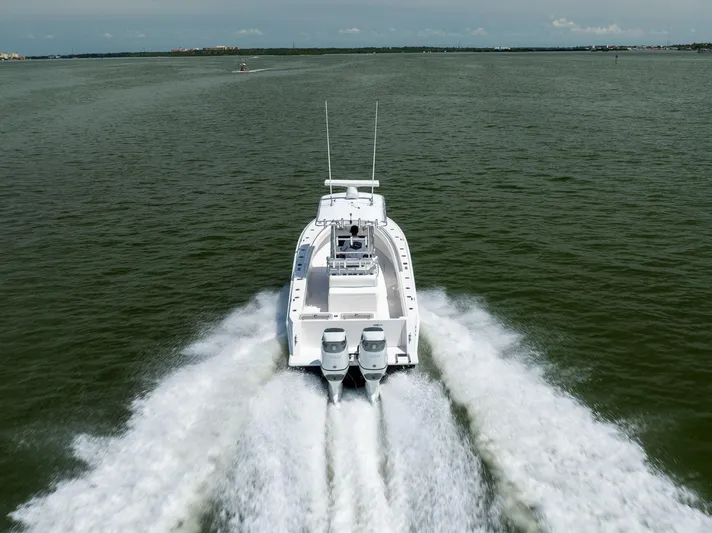  Yacht Photos Pics 2008 Contender 31 Open boat cruising on open water, rear view.