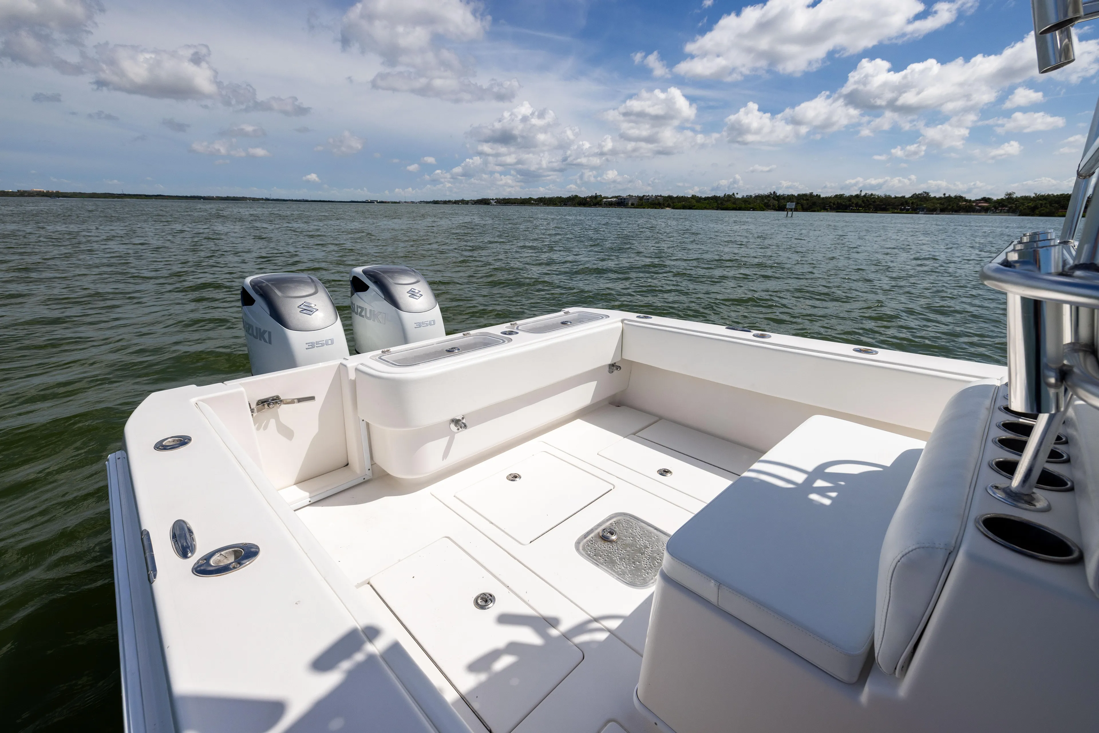  Yacht Photos Pics 2008 Contender 31 Open boat with dual Suzuki engines on calm water under a blue sky.