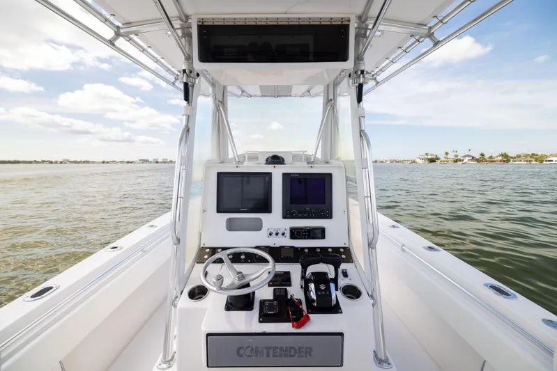  Yacht Photos Pics 2008 Contender 31 Open boat console with steering wheel and navigation screens on calm water.