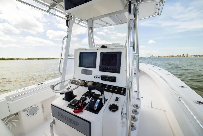  Yacht Photos Pics 2008 Contender 31 Open boat dashboard with steering wheel and navigation screens on open water.
