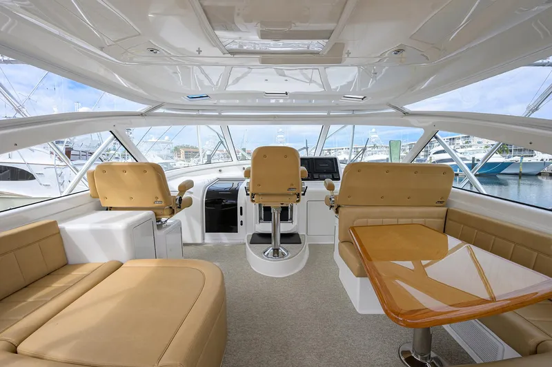  Yacht Photos Pics Interior of 2016 Viking 52 Open yacht with beige seating and wooden table.