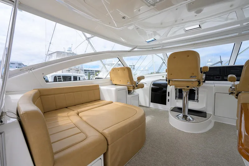  Yacht Photos Pics 2016 Viking 52 Open yacht interior with tan seating and helm chairs.