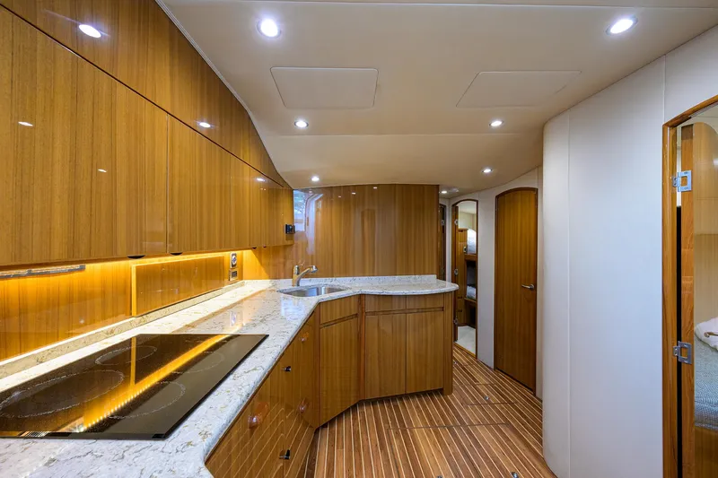  Yacht Photos Pics Luxurious kitchen interior of 2016 Viking 52 Open yacht with wood cabinetry and modern appliances.