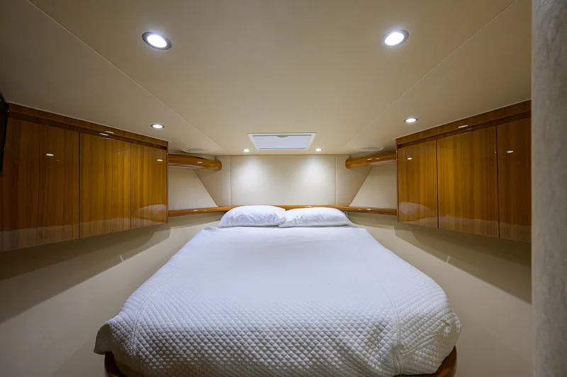  Yacht Photos Pics Luxurious cabin interior of 2016 Viking 52 Open yacht with cozy bed and wooden cabinetry.