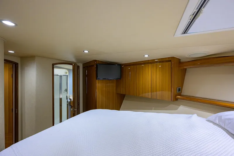  Yacht Photos Pics Luxurious cabin interior of 2016 Viking 52 Open yacht with wood paneling and TV.