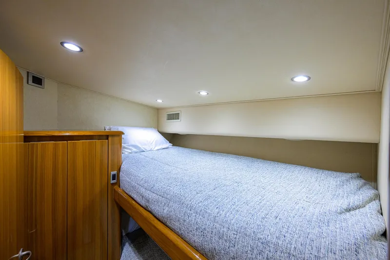  Yacht Photos Pics Cozy cabin interior of 2016 Viking 52 Open yacht with bed and wooden cabinetry.