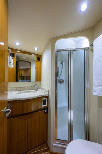  Yacht Photos Pics 2016 Viking 52 Open yacht bathroom with shower, wooden cabinetry, and modern lighting.