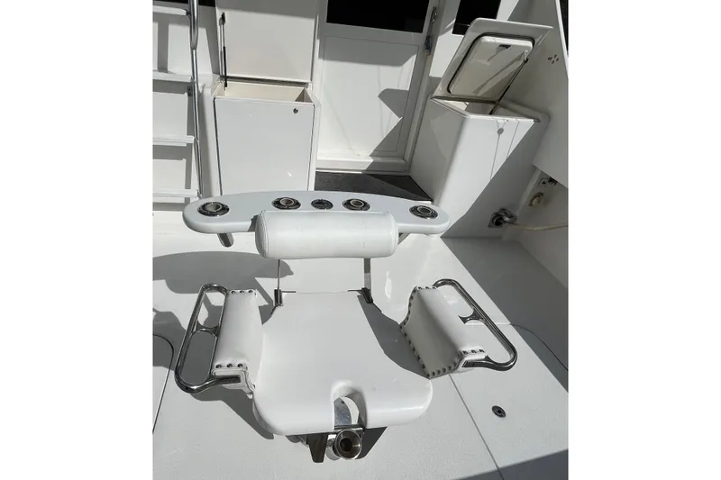 Next Yacht Photos Pics Fishing chair on 1999 Post 42 Convertible boat deck, featuring rod holders and white upholstery.