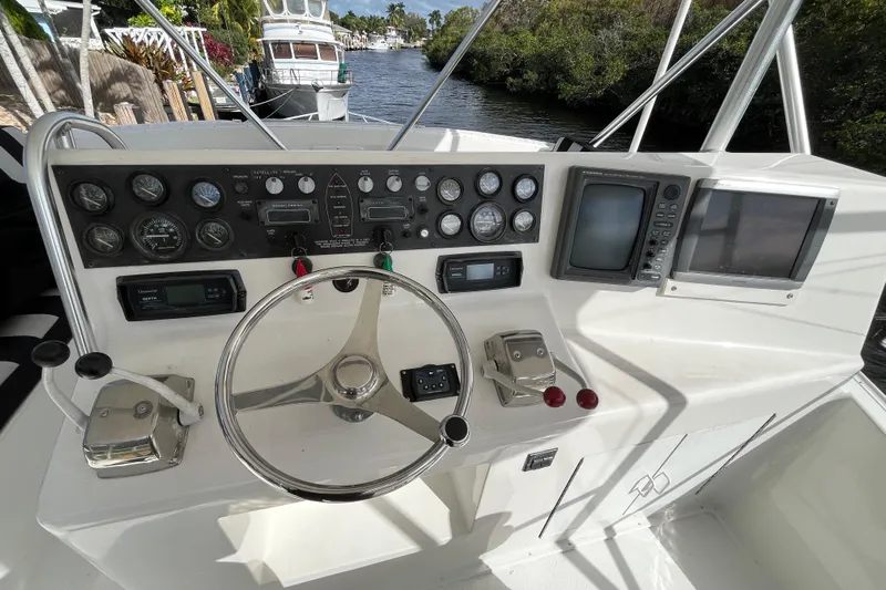 Next Yacht Photos Pics 1999 Post 42 Convertible boat helm with steering wheel, gauges, and navigation screens.