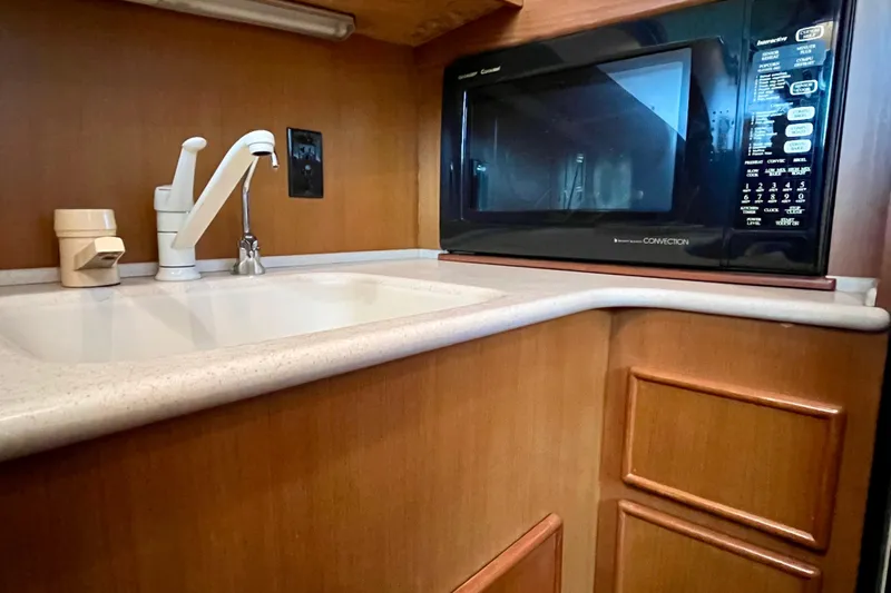 Next Yacht Photos Pics Kitchen area in a 1999 Post 42 Convertible yacht with sink and microwave.